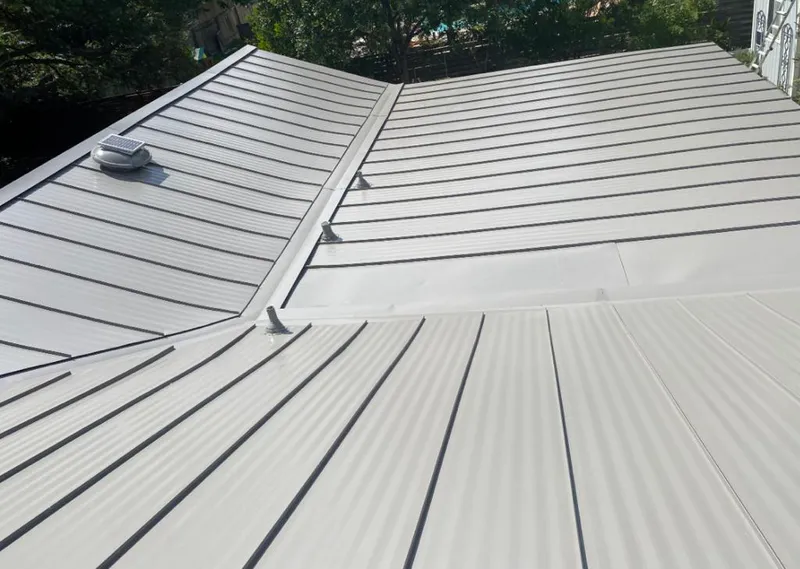 Solar attic fan installed on a metal roof for Roof Ventilation in Delhi Hills